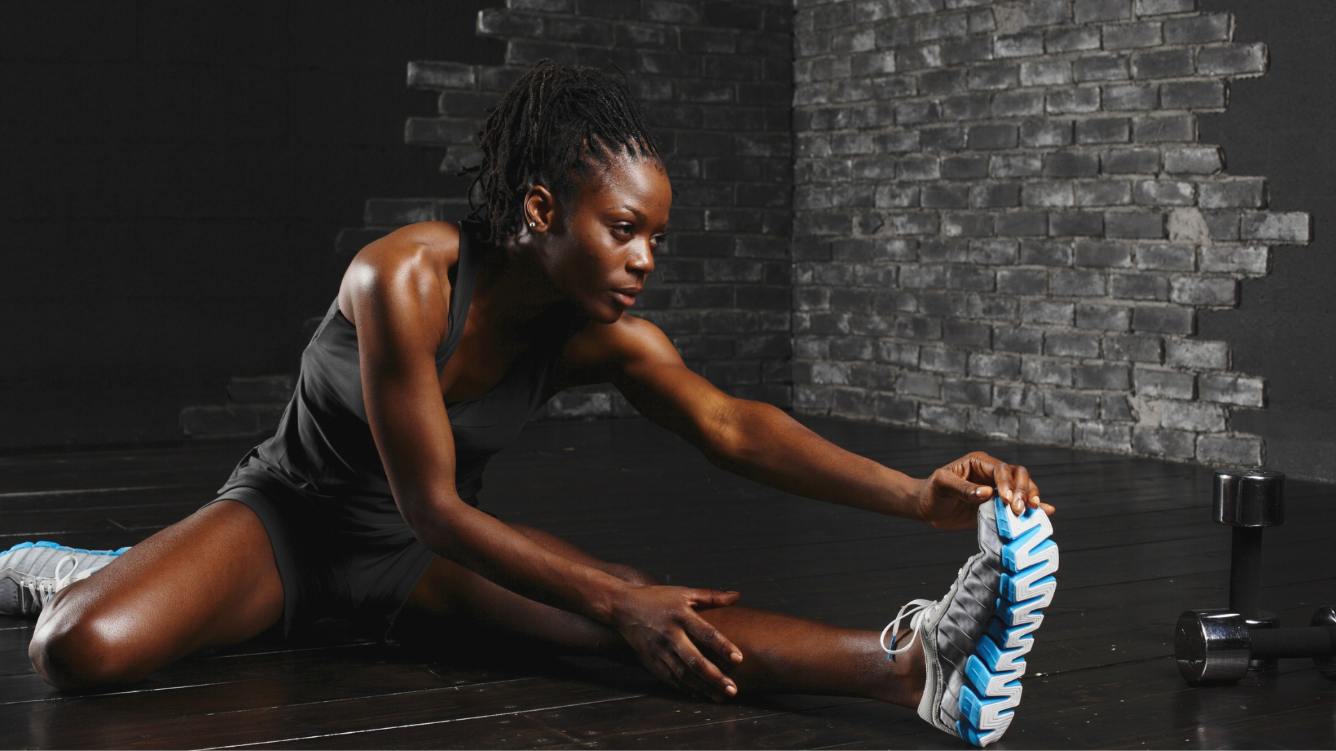 Athlete stretching her hamstring before training